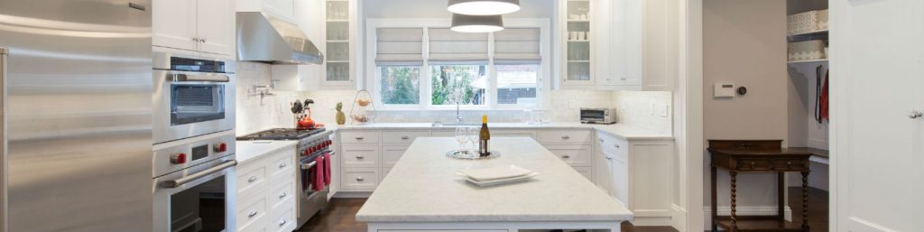 A photograph of a pristine, white kitchen.